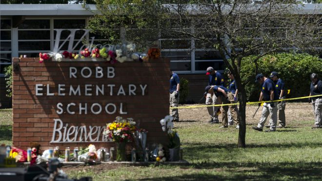 FILE - Investigators search for evidences outside Robb Elementary School in Uvalde, Texas, May 25, 2022, after an 18-year-old gunman killed 19 students and two teachers.  Four months after the Robb Elementary School shooting, the Uvalde school district on Friday, Oct. 7 pulled its entire embattled campus police force off the job following a wave of new outrage over the hiring of a former Texas state trooper who was part of the hesitant law enforcement response as a gunman killed 19 children and two teachers.(AP Photo/Jae C. Hong, File)